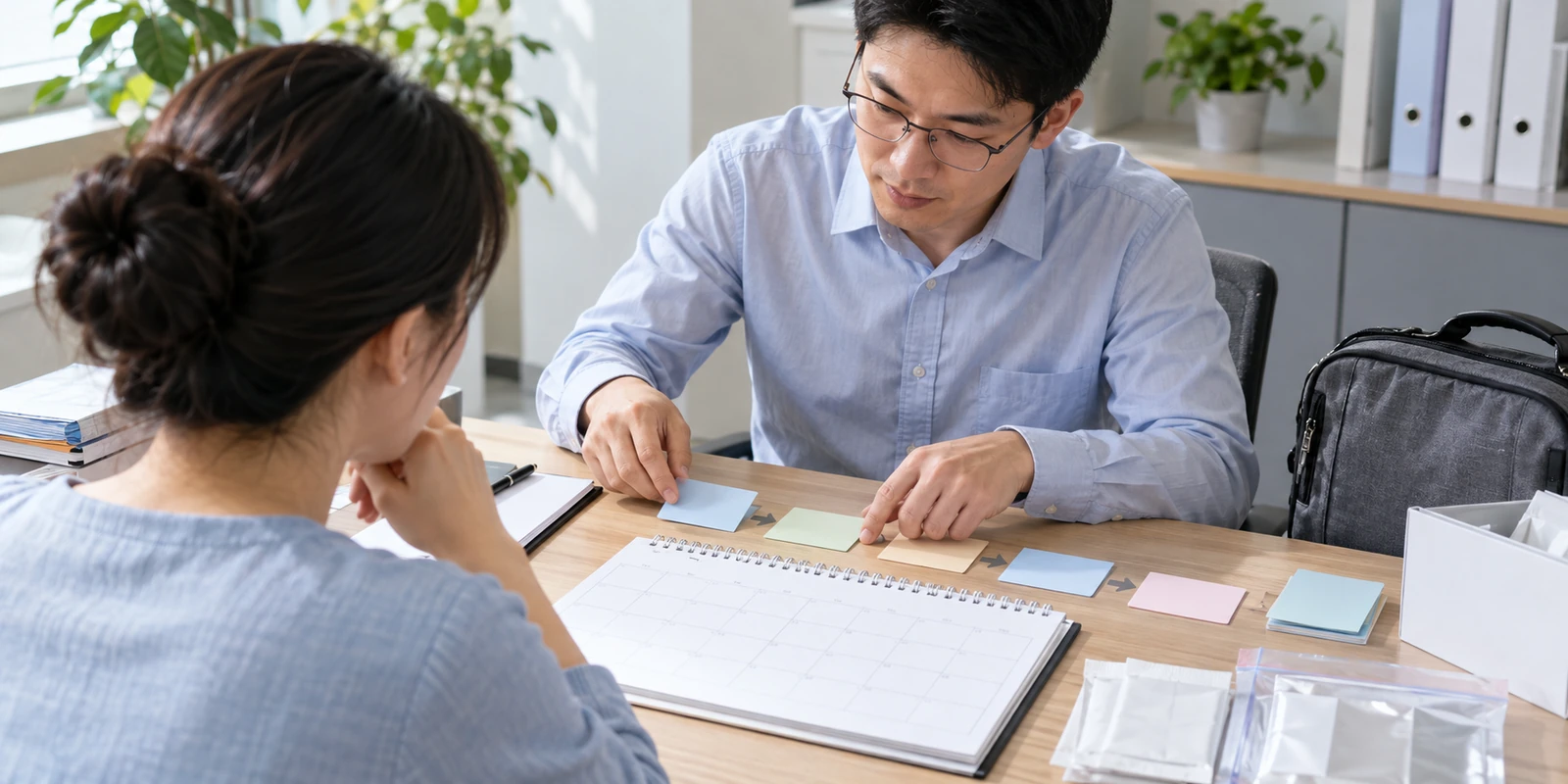 亲子鉴定成年人通过电话核对到访行程和时间安排 成年人在咨询桌前核对亲子鉴定到访与时间安排